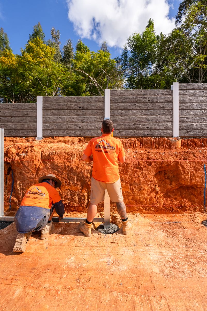 Crew installing retaining wall posts