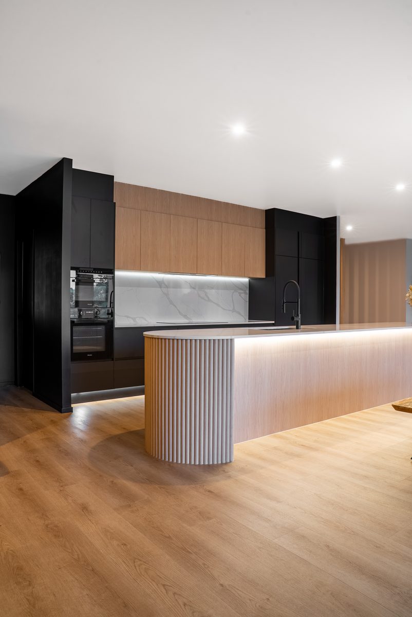 Black and oak kitchen with fluted island