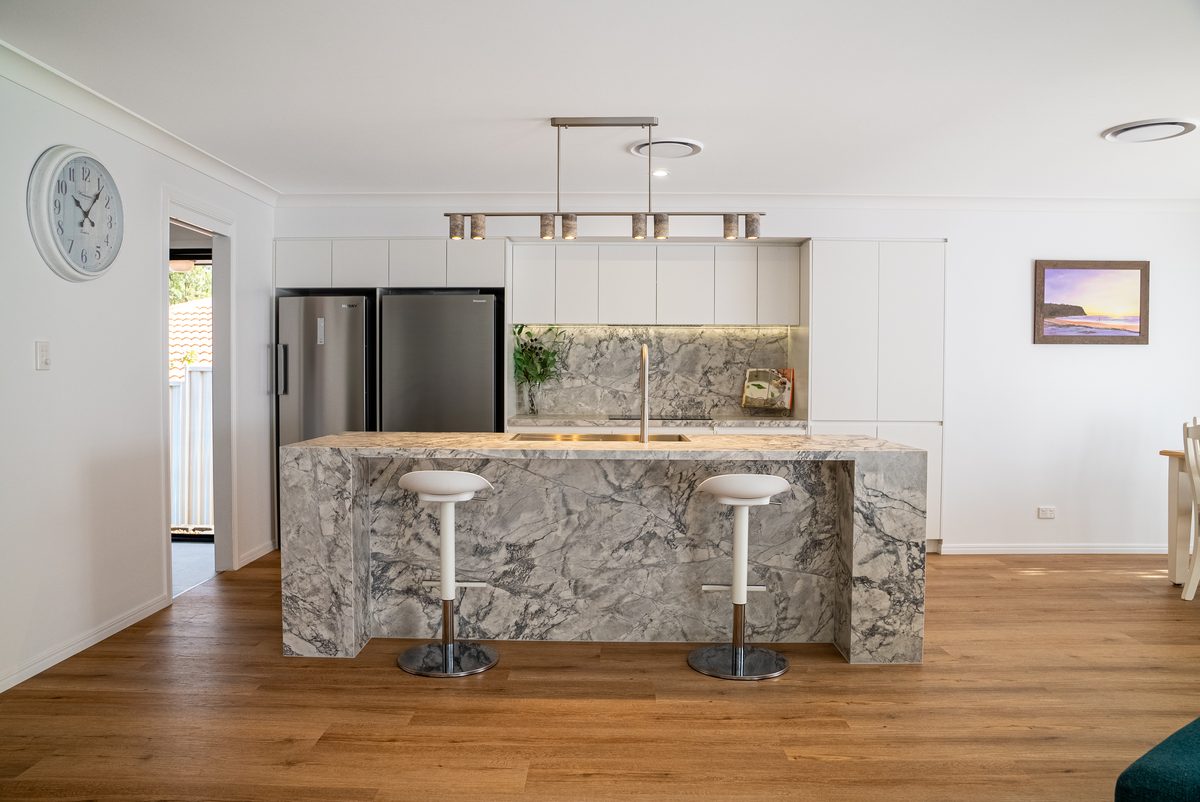 Marble island kitchen with white joinery