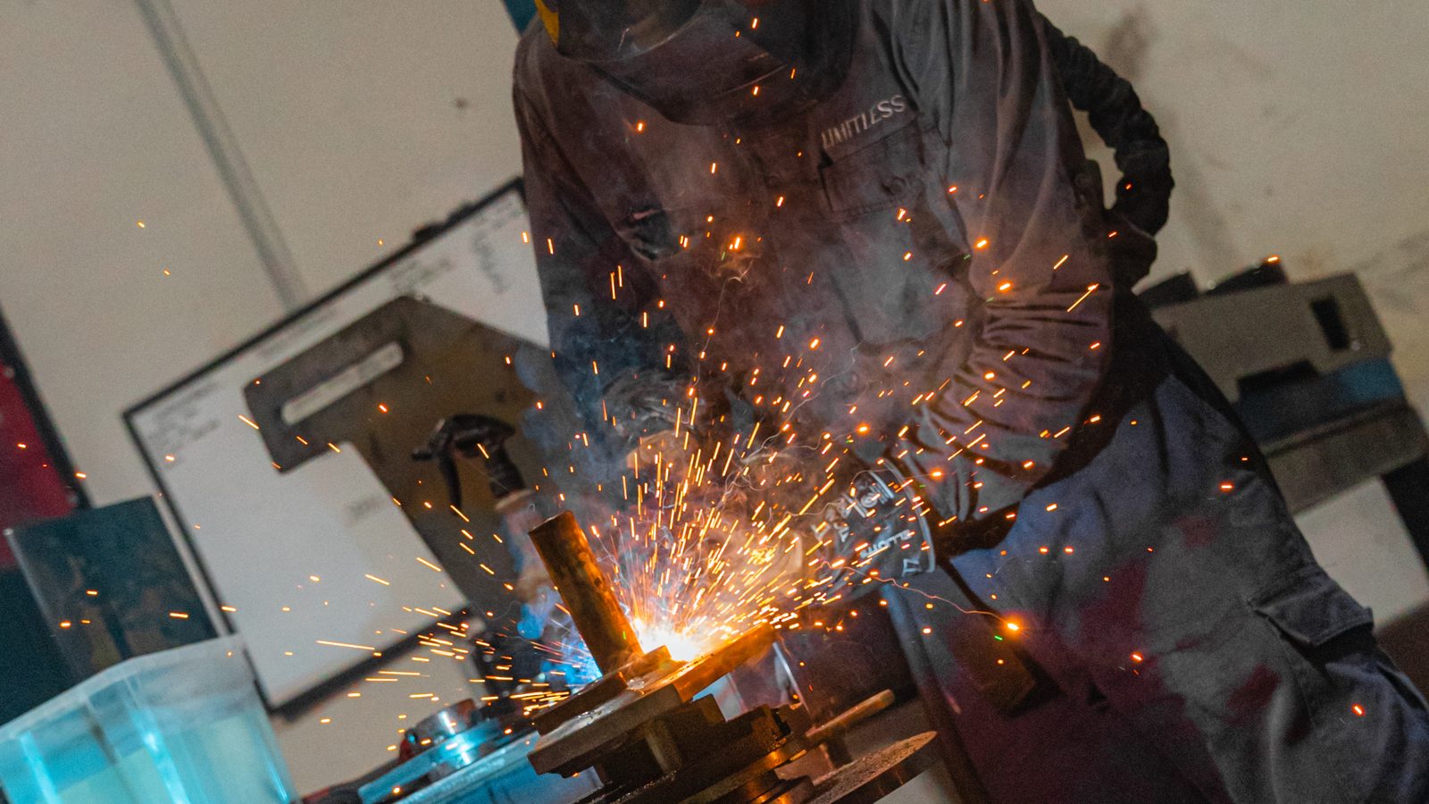 Welder fabricating an excavator attachment at Limitless Attachments
